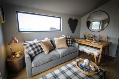 a living room with a couch and a mirror at Fawns Rest in Nantmel