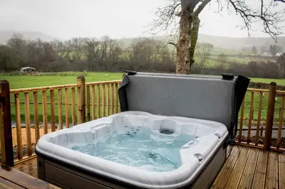 a hot tub sitting on a wooden deck at Buck Barn in Nantmel