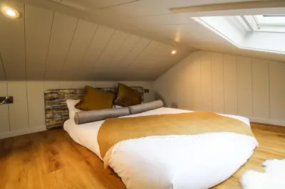 a bedroom with a large bed in a attic at Buck Barn in Nantmel