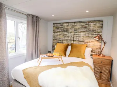 a bedroom with a bed and a brick wall at Doe Lodge in Rhayader