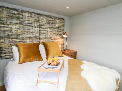 a bedroom with a bed with a tray of fruit on it at Doe Lodge in Rhayader