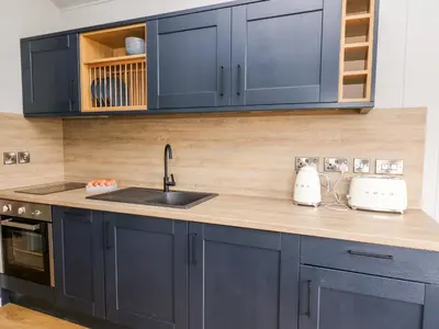 a kitchen with navy blue cabinets and a sink at Fawns Rest in Rhayader