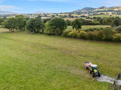 a tractor is driving through a field at Fawns Rest in Rhayader