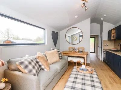 a living room with a couch and a table at Fawns Rest in Rhayader