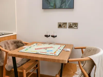 a dining room table with two glasses of wine at Tin Shed in Rhayader