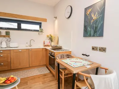 a kitchen with a wooden table and a kitchen with a sink at Tin Shed in Rhayader