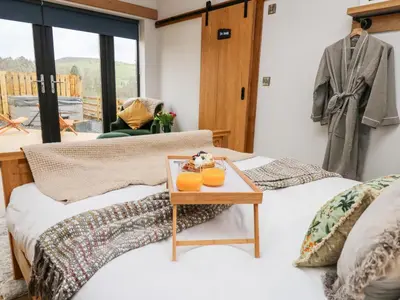 two twin beds in a room with a table at Tin Shed in Rhayader