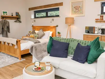 a living room with a couch and two beds at Tin Shed in Rhayader