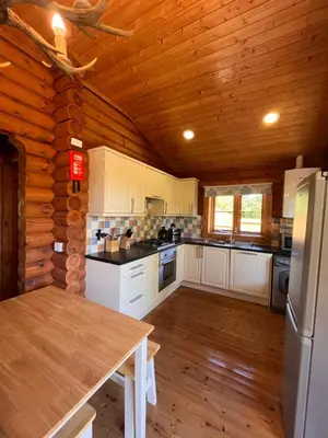a kitchen in a log cabin with a wooden ceiling at Beautiful 2 Bedroom Log Cabin With Private Hot Tub - Elm in Leominster