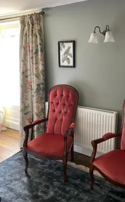 a room with two red chairs and a window at Hurdley House-Georgian Town House in Montgomery