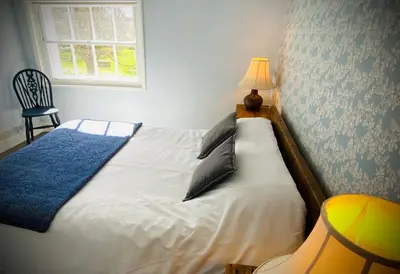 a bedroom with a bed with a lamp and a window at Superbly Located Handsome Georgian Townhouse - Pass the Keys in Shrewsbury