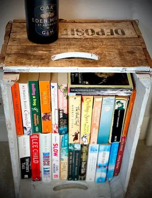 a crate full of books sitting next to a bottle of wine at Superbly Located Handsome Georgian Townhouse - Pass the Keys in Shrewsbury