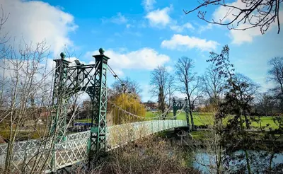 a bridge over a river in a park at Superbly Located Handsome Georgian Townhouse - Pass the Keys in Shrewsbury