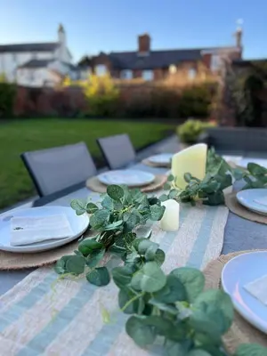 a table with plates and candles and plants on it at Quaint Georgian house with Parking & Huge Garden 10 mins walk from town in Shrewsbury