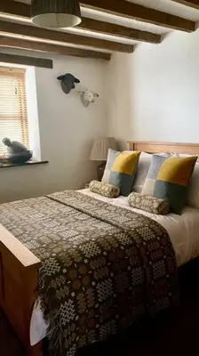 a bedroom with a bed with a blanket and a window at Hay On Wye Welsh Townhouse in Hay centre in Hay-on-Wye