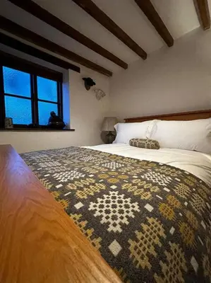 a bedroom with a bed with a rug on it at Hay On Wye Welsh Townhouse in Hay centre in Hay-on-Wye
