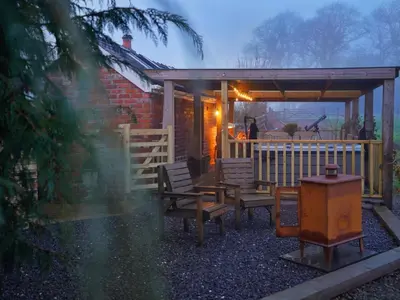 a house with a deck with benches and a porch at Romantic country cabin with log burner, spectacular views, spa hot tub - Brecon Beacons National Park dog friendly in Llangadog
