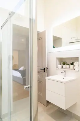 a white bathroom with a sink and a shower at The Old Glassworks by Bevolve in Shrewsbury