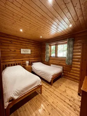 a room with two beds in a log cabin at Countryside 3 Bedroom Log Cabin With Private Hot Tub - Ash in Leominster