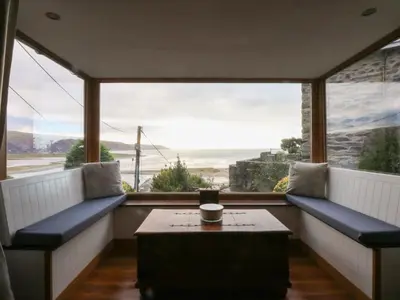 a room with a table and a large window at Ty'n-Y-Ffynnon Cottage in Barmouth