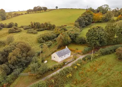 an aerial view of a white house in a field at Tranquil 1 bedroom cottage 15 mins drive to sea in Mydroilin