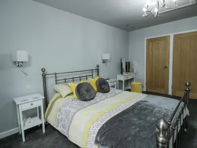 a bedroom with a large bed with yellow pillows at Wesleyan House in Oswestry