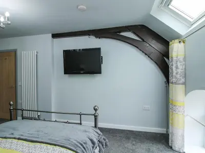 a bedroom with a bed and a tv on the wall at Wesleyan House in Oswestry