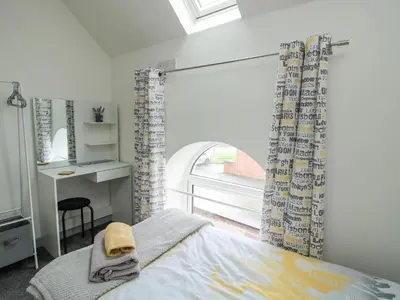 a bedroom with a bed and a desk and a window at Wesleyan House in Oswestry