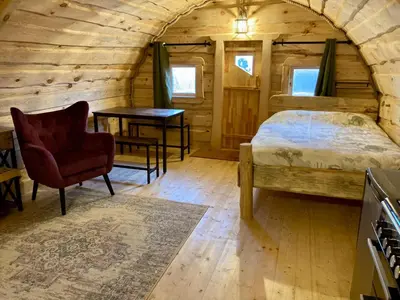 a bedroom with a bed and a table and a chair at The Prancing Moose in Ystrad Meurig