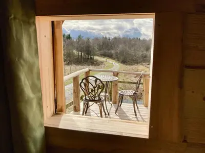 a view of a balcony with two chairs and a table at The Prancing Moose in Ystrad Meurig