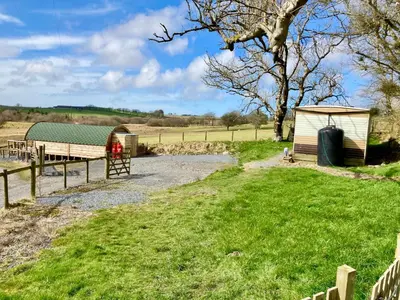 a barn and a shed in a field at The Prancing Moose in Ystrad Meurig