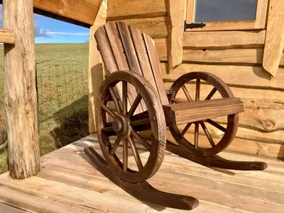 a wooden bench sitting on the porch of a cabin at The Prancing Moose in Ystrad Meurig