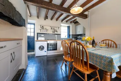 a kitchen with a table and chairs and a kitchen with a washing machine at 2 Bed in Dolgellau oc-wah671 in Dolgellau