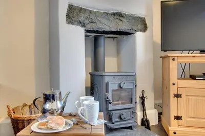 a wood stove with a plate of food on a table at 2 Bed in Dolgellau oc-wah671 in Dolgellau