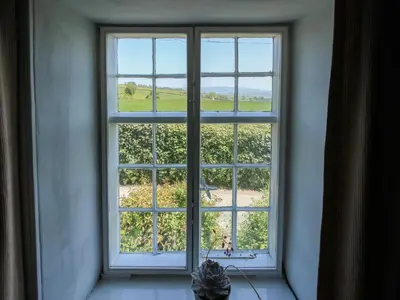 a window with a view of a field of grapes at 1 Hetfield Cottages in Bishops Castle