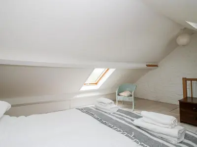 a bedroom with a white bed and a chair at 1 Hetfield Cottages in Bishops Castle