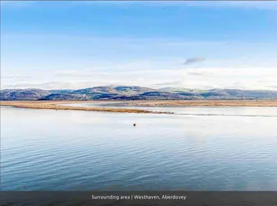 a body of water with mountains in the background at Seaview Apartment Westhaven in Aberdyfi