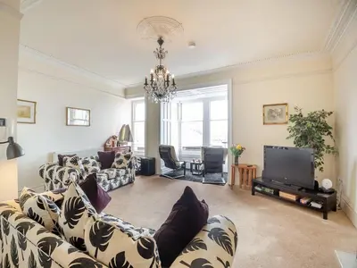 a living room with a couch and a tv at Seaview Apartment Westhaven in Aberdyfi
