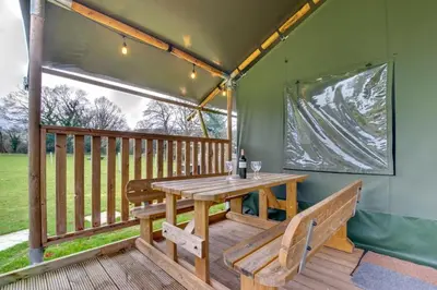 a wooden table on a deck with a bench at 3 Bed in Talybont-on-Usk oc-wal376 in Talybont