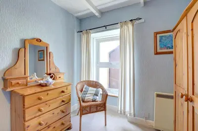 a bedroom with a dresser and a mirror and a chair at 4 Bed in New Quay oc-was409 in New Quay