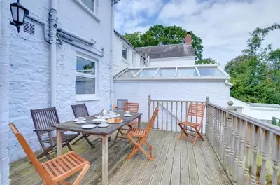 a wooden deck with a table and chairs on a balcony at 4 Bed in New Quay oc-was409 in New Quay