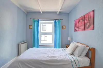 a bedroom with a bed with blue walls and a window at 4 Bed in New Quay oc-was409 in New Quay