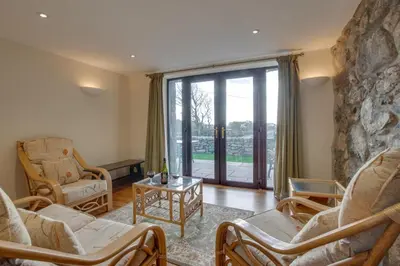 a living room with chairs and a stone wall at 2 Bed in Barmouth oc-wah699 in Talybont