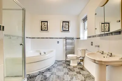 a bathroom with a tub and a toilet and a sink at 5 Bed in Aberystwyth oc-wan443 in Llanychaiarn