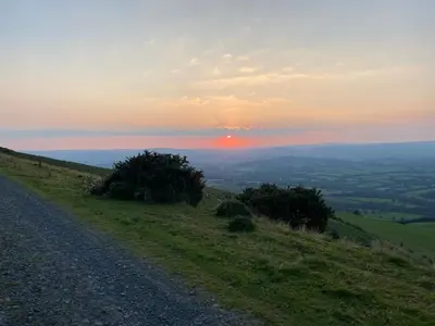 a dirt road on the side of a hill with a sunset at 3 Bed in Builth Wells oc-wal257 in Maesmynis