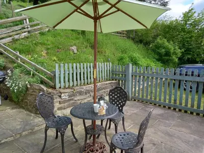 a table and chairs with an umbrella on a patio at 3 Bed in Builth Wells oc-wal257 in Maesmynis