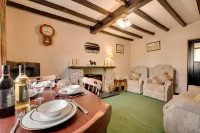 a living room with a wooden table with wine glasses at 2 Bed in Corwen oc-waf161 in Carrog