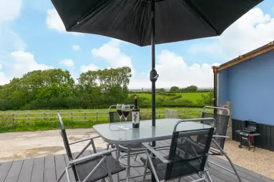 a table with a glass of wine and an umbrella at 1 Bed in Aberystwyth oc-bow182 in Rhostie