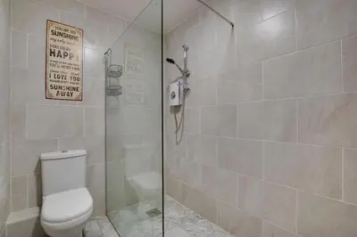a bathroom with a toilet and a glass shower at 1 Bed in Aberystwyth oc-bow182 in Rhostie