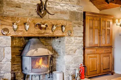 a stone fireplace with a stove in a room at 4 Bed in Builth Wells oc-bow197 in Builth Wells